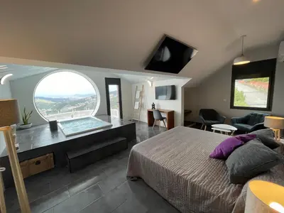a bedroom with a bed and a large window at Petit Mirador in Torrelles de Llobregat