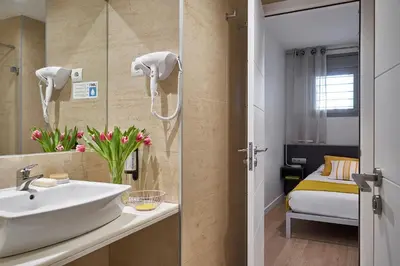 a bathroom with a sink and a mirror at Lugaris Rambla Apartments in Barcelona