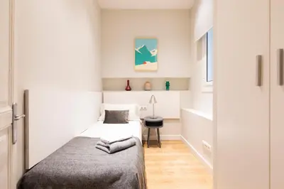 a small bedroom with a bed and a desk at Aspasios Urquinaona Apartments in Barcelona