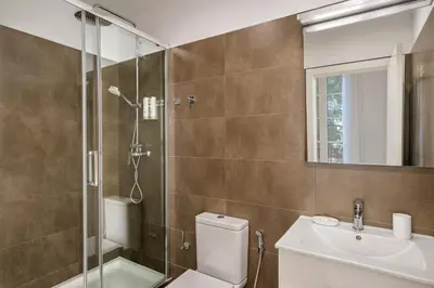 a bathroom with a shower and a toilet and a sink at Aspasios Urquinaona Apartments in Barcelona