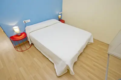 a bedroom with a white bed and a red table at Barcelona City Apartment in Barcelona