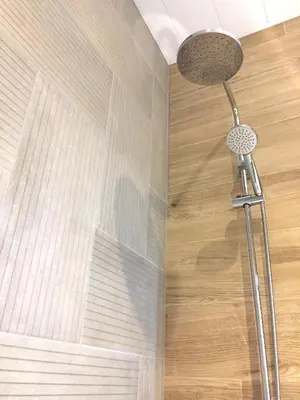 a shower head in a bathroom with a wooden floor at Hip Karma Hostel in Barcelona