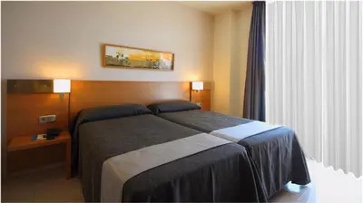 a hotel room with a bed and a window at AQUA Hotel Nostre Mar Apartments in Pineda de Mar