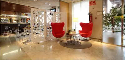 a restaurant with red chairs and a table in a room at AQUA Hotel Nostre Mar Apartments in Pineda de Mar
