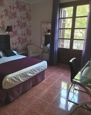 a hotel room with a bed and a window at Hotel Lloret Ramblas in Barcelona