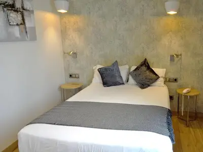 a bedroom with a white bed with two pillows at Hotel Lloret Ramblas in Barcelona