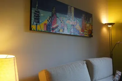 a living room with a couch and a painting on the wall at ApartEasy - Montjuïc & Fira in Barcelona