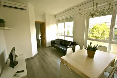 a living room with a table and a couch at ApartEasy - Plaza España Deluxe in Barcelona