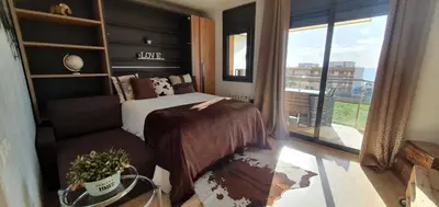 a bedroom with a bed and a chair and a window at Apartment Beach Front Canet in Canet de Mar
