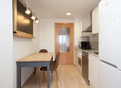 a kitchen with a table and a dining room table at Apartment Beach Front Canet in Canet de Mar