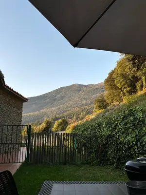 a garden with a fence and a mountain in the background at Can Rovira de Fogars in Montseny