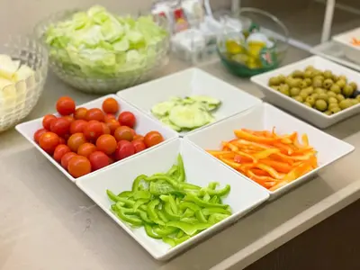 a counter topped with white plates of fruits and vegetables at SM Hotel Teatre Auditori in Barcelona