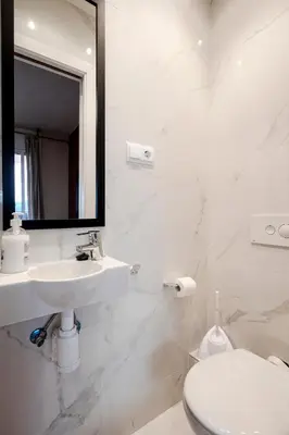 a bathroom with a sink and a toilet and a mirror at Three Bedroom Apartment in Sants in Barcelona