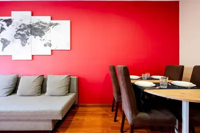 a dining room with a table and a red wall at Three Bedroom Apartment in Sants in Barcelona