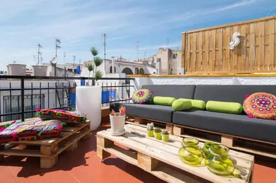 a balcony with a couch and tables on a roof at Unique studio Apartment with amazing terrace Sitges centre beach in Sitges