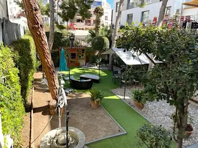 a garden with green grass and trees and plants at 3 bedroom Apartment with private garden on top location Sitges centre beach in Sitges
