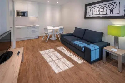 a living room with a blue couch and a table at Apartments Playa de Castelldefels in Castelldefels