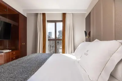 a bedroom with a white bed and a window at Suites Center Barcelona in Barcelona