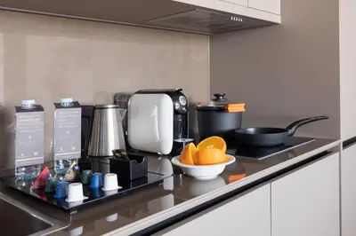 a kitchen counter with a coffee maker and oranges on it at Suites Center Barcelona in Barcelona