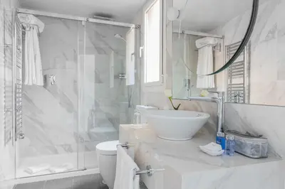 a white bathroom with a sink and a shower at Suites Center Barcelona in Barcelona