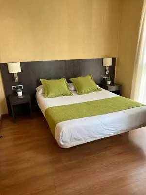 a bedroom with a large bed with green pillows at Hotel 1948 Manresa in Manresa