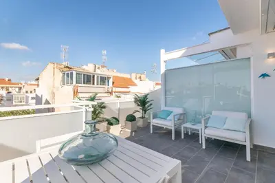 a patio with a table and chairs on a balcony at Beach penthouse Sitges Rentals in Sitges