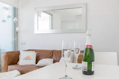 a bottle of wine sitting on a table with two glasses at Beach penthouse Sitges Rentals in Sitges