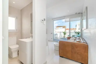 a bathroom with a couch and a sink and a toilet at Beach penthouse Sitges Rentals in Sitges