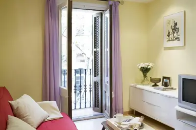 a living room with a red couch and a window at ApartEasy - Sant Antoni Market in Barcelona