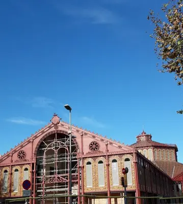 a large pink building with a blue sky in the background at ApartEasy - Sant Antoni Market in Barcelona