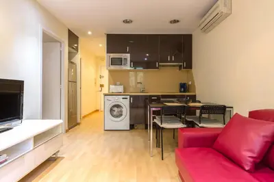 a living room with a red couch and a kitchen at ApartEasy - Sant Antoni Market in Barcelona