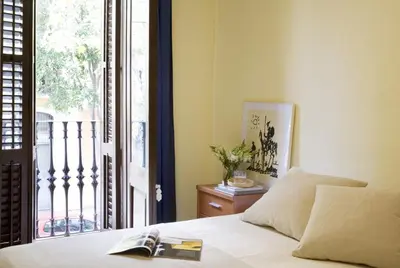 a bedroom with a bed with a book on it at ApartEasy - Sant Antoni Market in Barcelona