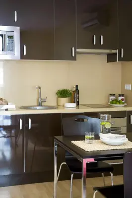 a kitchen with black cabinets and a table with chairs at ApartEasy - Sant Antoni Market in Barcelona
