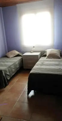 two beds in a room with a large window at Casa Mar y Piscina (solo familias) in Sant Cebrià de Vallalta