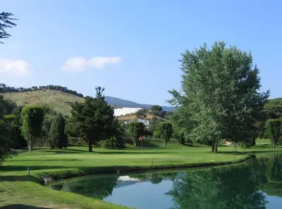 a golf course with a pond in the middle at Casa Mar y Piscina (solo familias) in Sant Cebrià de Vallalta
