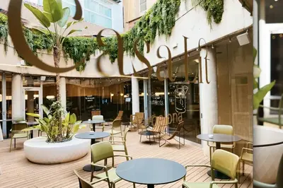 a patio with tables and chairs in front of a building at Casa Lit Barcelona in Barcelona