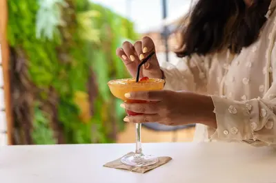 a woman is holding a glass with a grapefruit at Casa Lit Barcelona in Barcelona