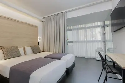 a hotel room with two beds and a table at Casa Lit Barcelona in Barcelona