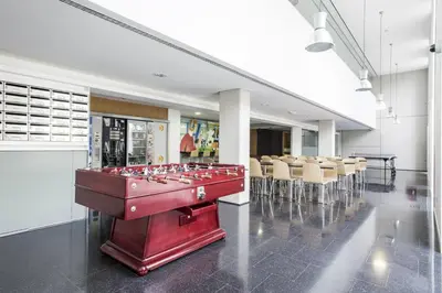 a large red pool table in a room with chairs at Residencia Universitaria Resa Roberto de Nobili in Sant Cugat del Vallès