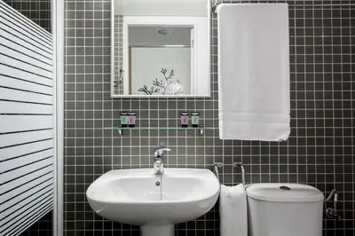 a bathroom with a sink and a toilet and a mirror at Residencia Universitaria Resa Roberto de Nobili in Sant Cugat del Vallès
