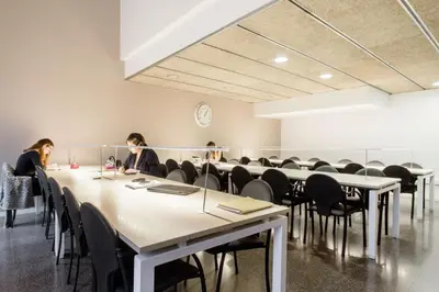 two women sitting at tables in a room with chairs at Residencia Universitaria Resa La Ciutadella in Barcelona