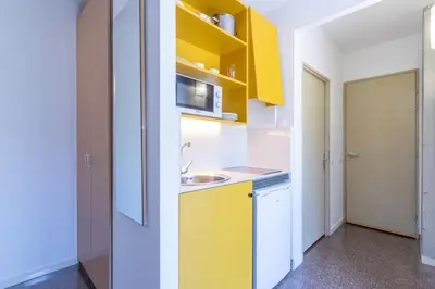 a kitchen with yellow cabinets and a sink at Residencia Universitaria Resa La Ciutadella in Barcelona