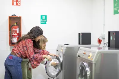 a woman and a child playing with a washing machine at Residencia Universitaria Resa Campus del Mar in Barcelona
