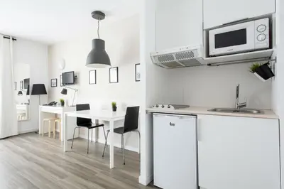 a white kitchen with a table and a microwave at Residencia Universitaria Resa Campus del Mar in Barcelona