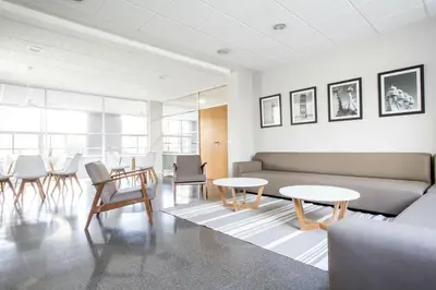 a living room with a couch and tables and chairs at Residencia Universitaria Resa Campus del Mar in Barcelona