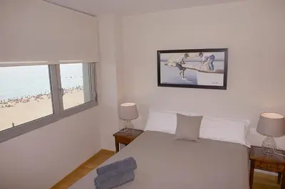 a bedroom with a bed and a view of the beach at Great Sea-Side Barcelona Apartment in Badalona