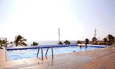 a swimming pool with the ocean in the background at Great Sea-Side Barcelona Apartment in Badalona