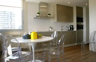 a kitchen with a white table and chairs in a room at Great Sea-Side Barcelona Apartment in Badalona