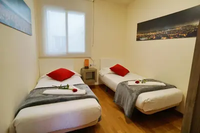 two beds in a small room with a window at Barcelona4Seasons - Central Palace in Barcelona