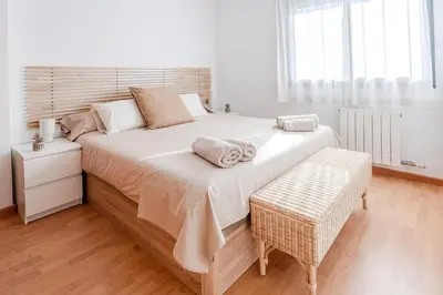 a large bed with two pillows on it in a bedroom at Capricho Apartamento Sitges in Sitges